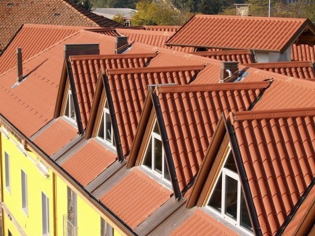 Un edificio amarillo con un techo de tejas rojas