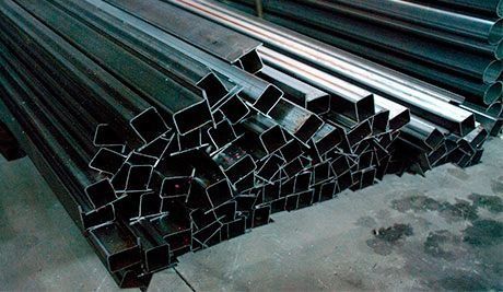 Una pila de tubos de metal están apilados uno encima del otro en el suelo.