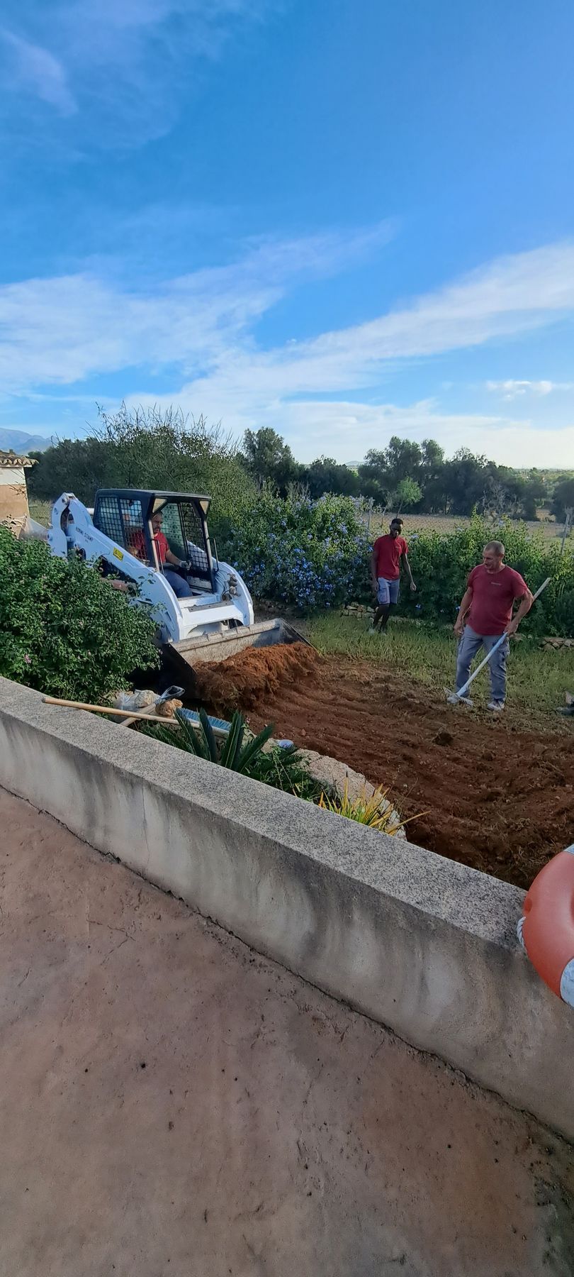Amplio garaje moderno con suelo de hormigón pulido, banco de trabajo, armarios y estanterías de almacenamiento a lo largo de la pared trasera.