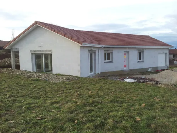 Une maison neuve au toit de tuiles rouges.