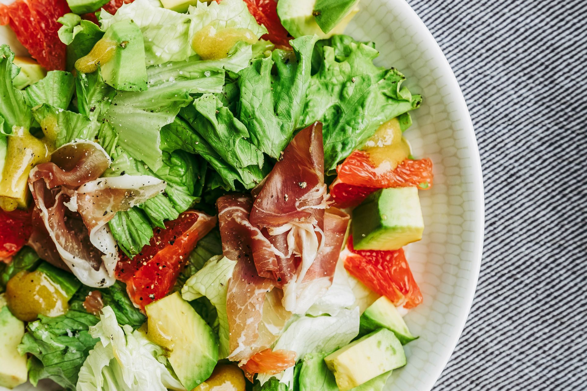 Salade composée à base de salade, tomate, courgette, jambon sec, avocat