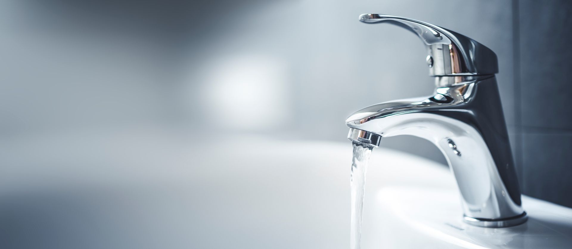 Robinet chromé faisant couler l'eau dans un évier