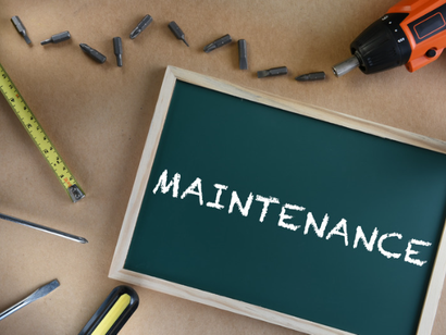 Outils d'entretien autour d'un tableau noir portant l'inscription maintenance.