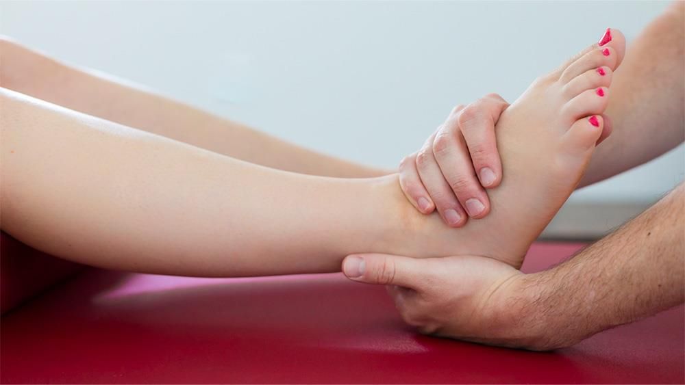 Eine Person gibt einer Frau eine Fußmassage.