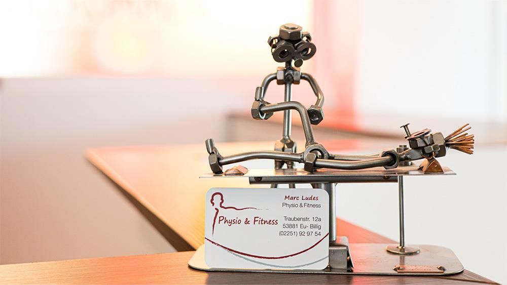 Eine Statue eines Mannes, der neben einer Visitenkarte auf einem Tisch sitzt.