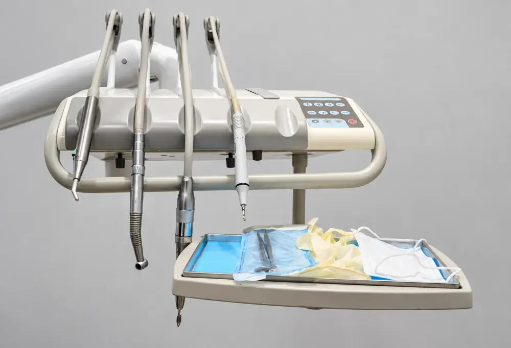 Sillón dental con instrumental incorporado y una bandeja con herramientas y suministros dentales