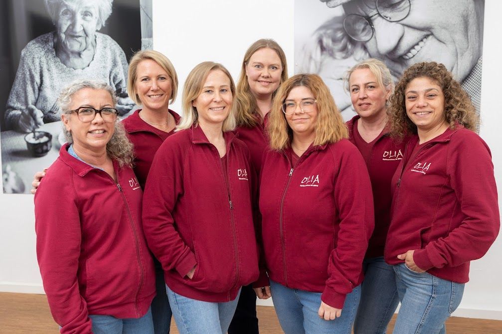 Mitarbeiterinnen Olia: Eine Gruppe von Frauen in roten Sweatshirts posiert für ein Foto.