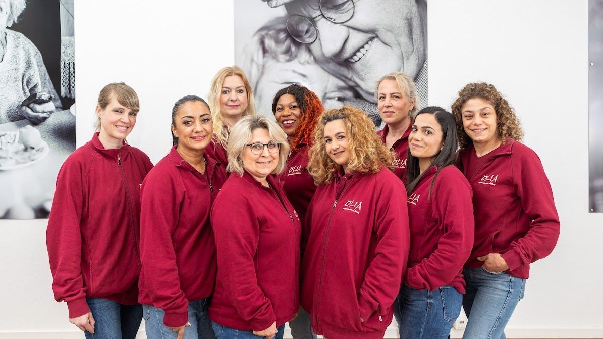 Mitarbeiterinnen Olia: Eine Gruppe von Frauen in roten Sweatshirts posiert für ein Foto.