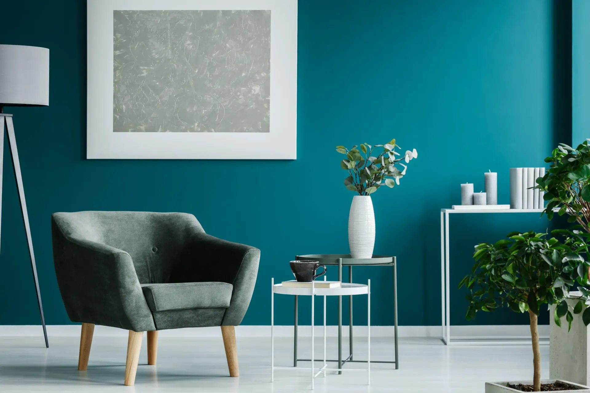 Una sala de estar con paredes azules, una silla, una mesa y una lámpara.