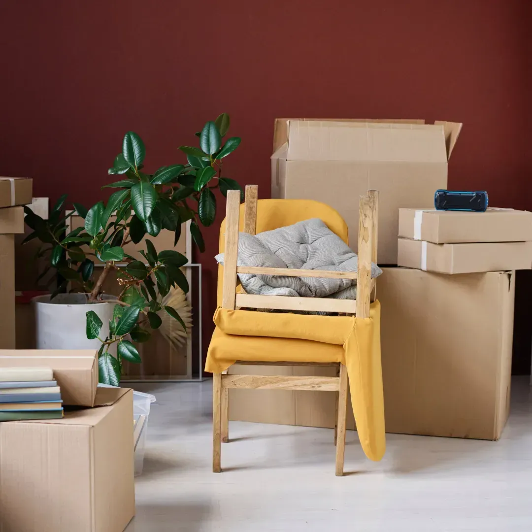 Una silla está sentada en una habitación rodeada de cajas de cartón.