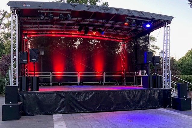 eine große , schwarze Bühne mit roten und blauen Lichtern darauf