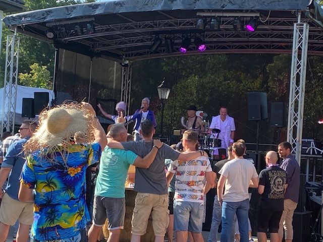 eine Gruppe von Menschen steht vor einer Bühne und tanzt