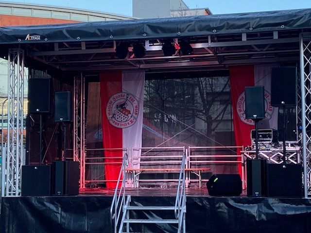 eine kleine Bühne mit einer roten und weißen Fahne darauf