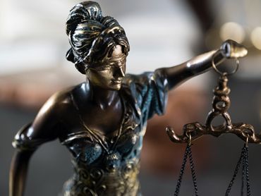 Una estatua de una mujer sosteniendo una balanza de la justicia.