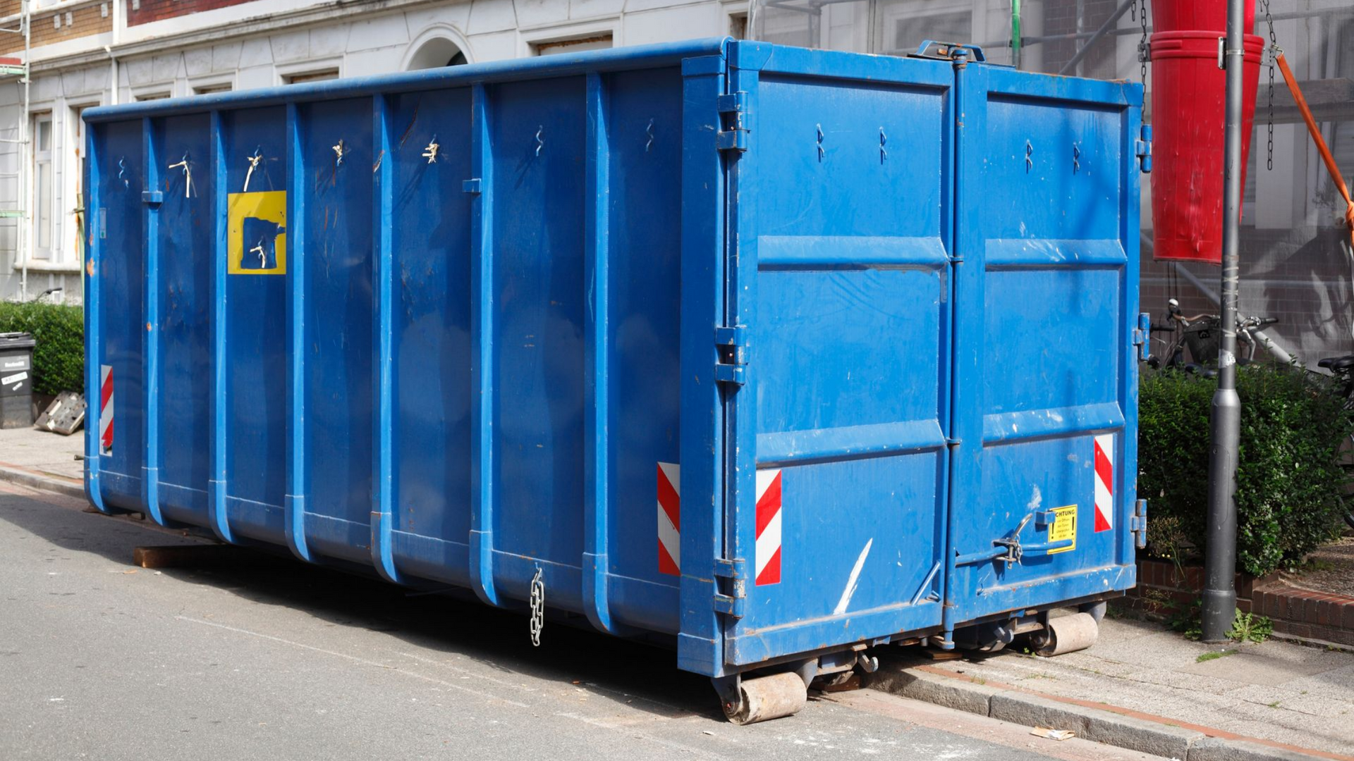 Benne bleue dans une rue de la ville, prête à être éliminée.