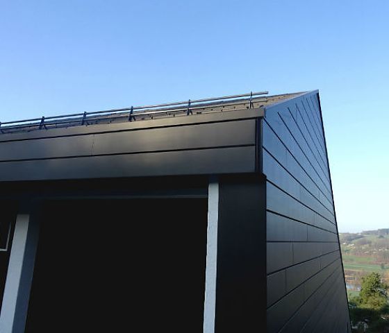 Ein schwarzes Gebäude mit einem blauen Himmel im Hintergrund