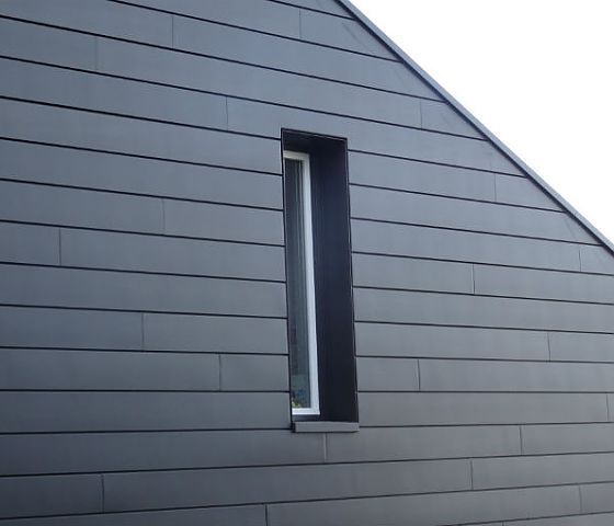 Ein Fenster an der Seite eines Gebäudes mit schrägem Dach