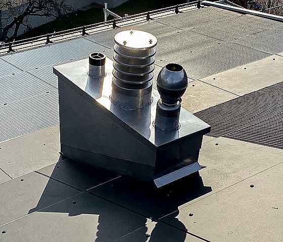 Ein Edelstahlkamin befindet sich auf dem Dach eines Gebäudes