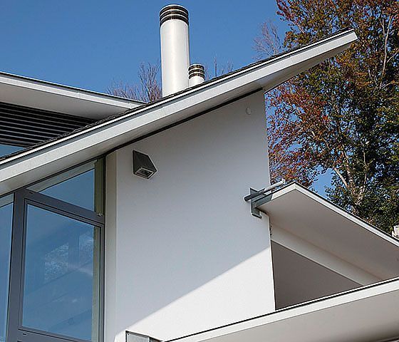 Ein weißes Haus mit einem Schornstein auf dem Dach