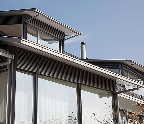 Ein Haus mit vielen Fenstern und einem Schornstein auf dem Dach.