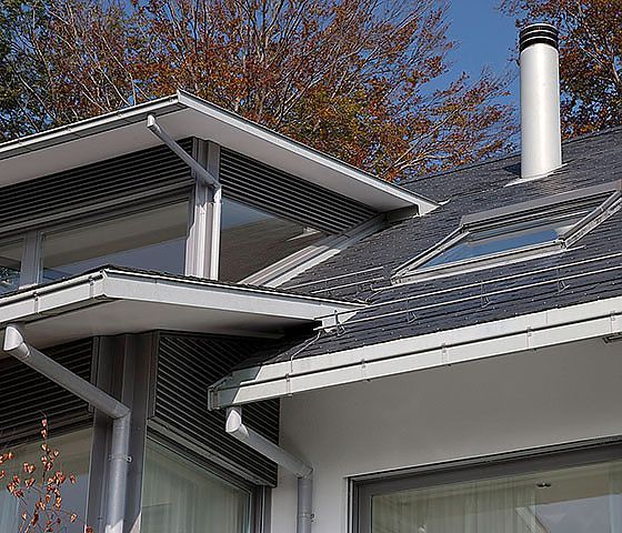 Das Dach eines Hauses mit einem Oberlicht und einem Schornstein.