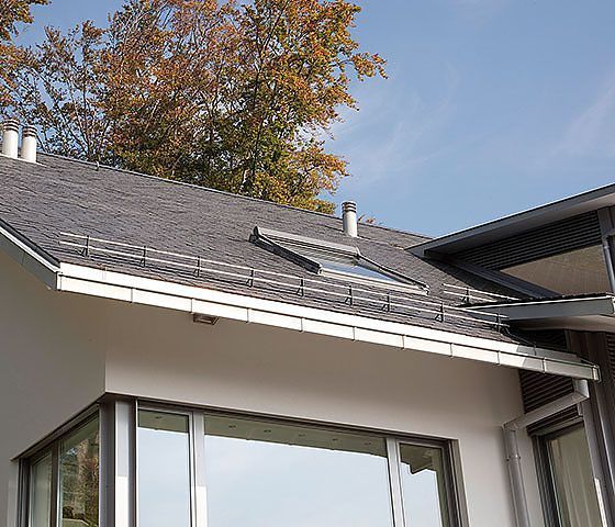 Ein Haus mit einem Dach, auf dem sich ein Oberlicht befindet.