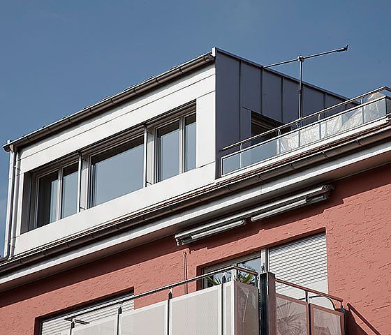 Ein Gebäude mit einem Balkon auf dem Dach