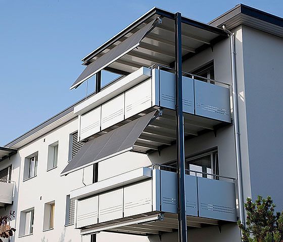 Ein Gebäude mit einem Balkon mit einer grauen Markise darauf