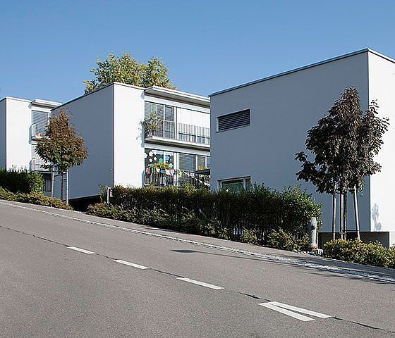 Eine Reihe weißer Gebäude auf einem Hügel neben einer Straße