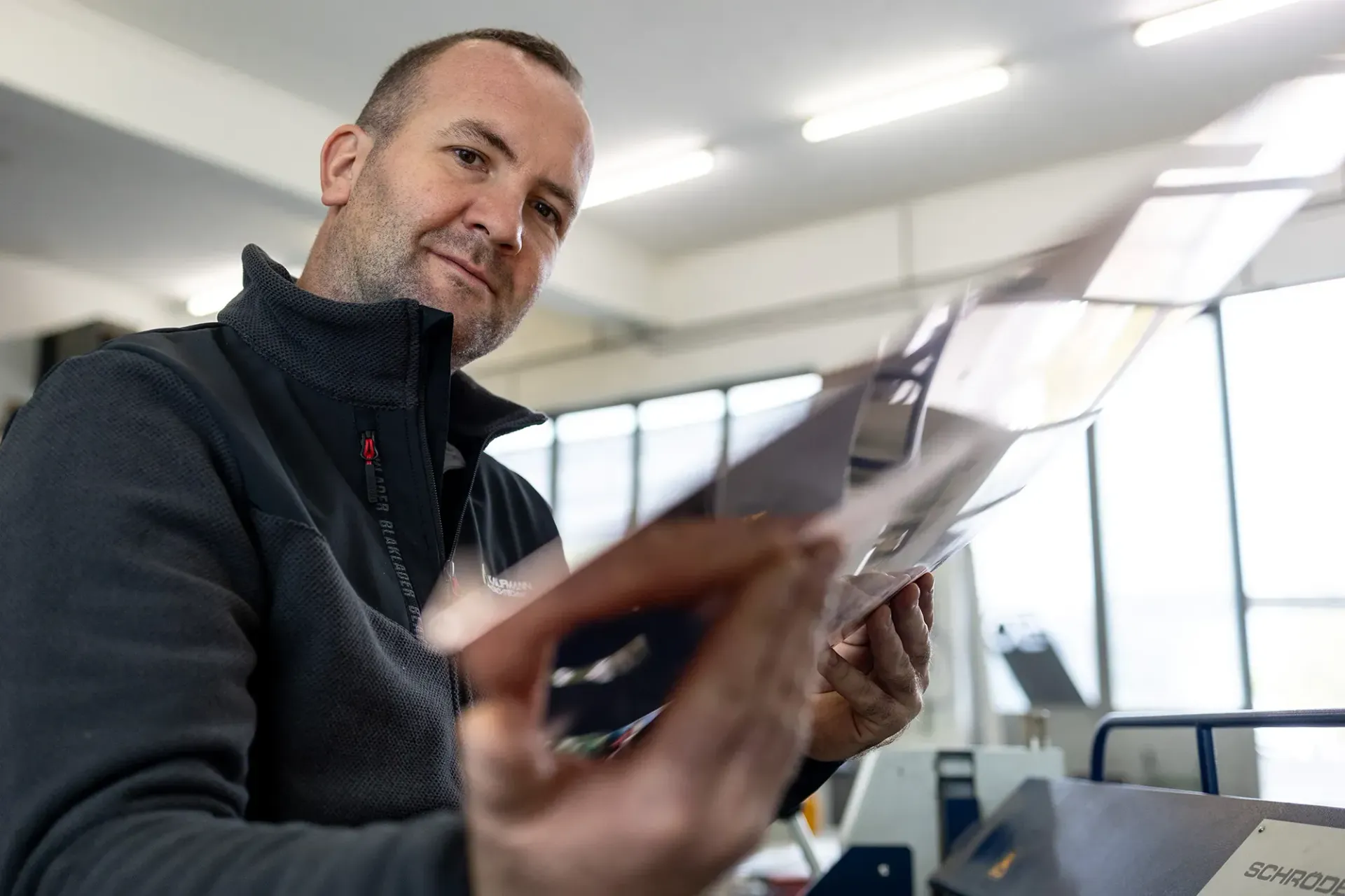 Ein Mann mit gelben Handschuhen arbeitet auf einem Dach.