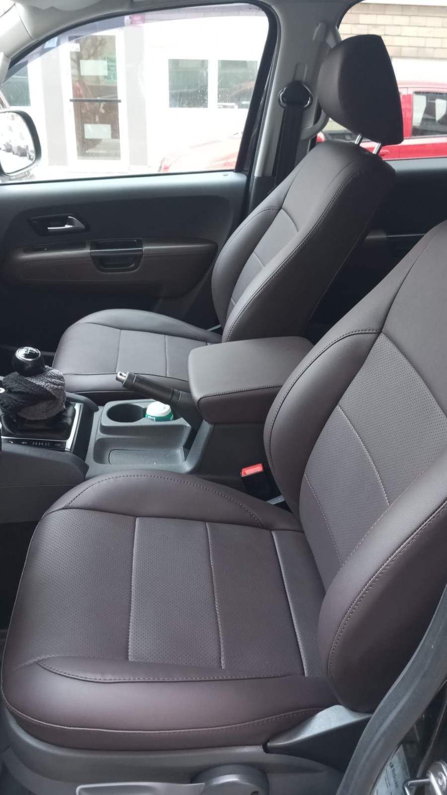 Interior del coche con asientos delanteros y consola central negros, visto desde el lado del pasajero.