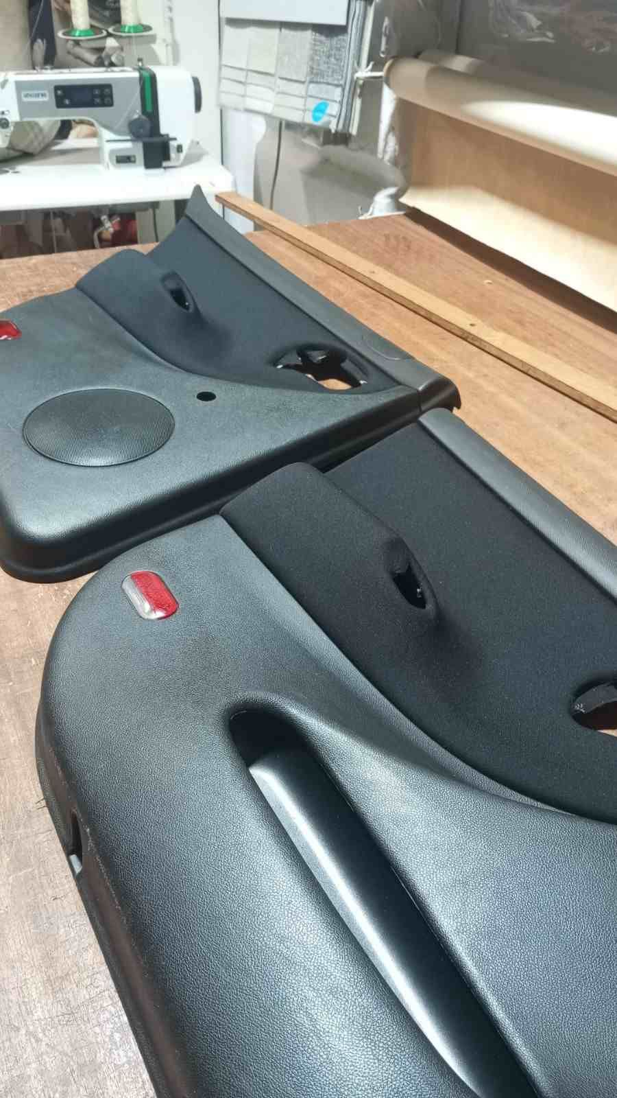 Dos piezas negras curvas de plástico con forma de bandeja, con recortes circulares y ranuras.