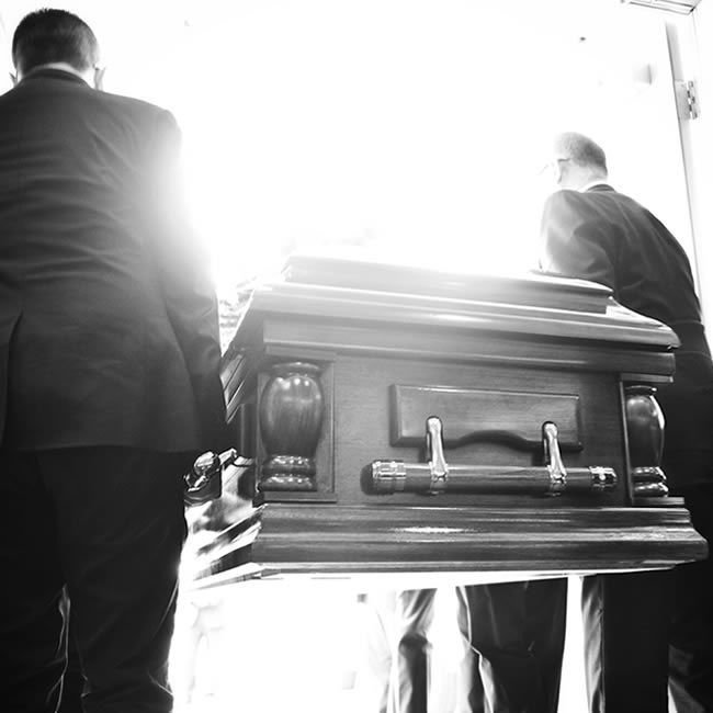 Deux personnes transportent un cercueil