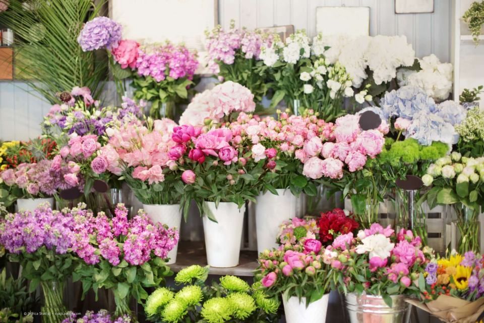 Blumensträuße in Eimern vor einem Blumenladen