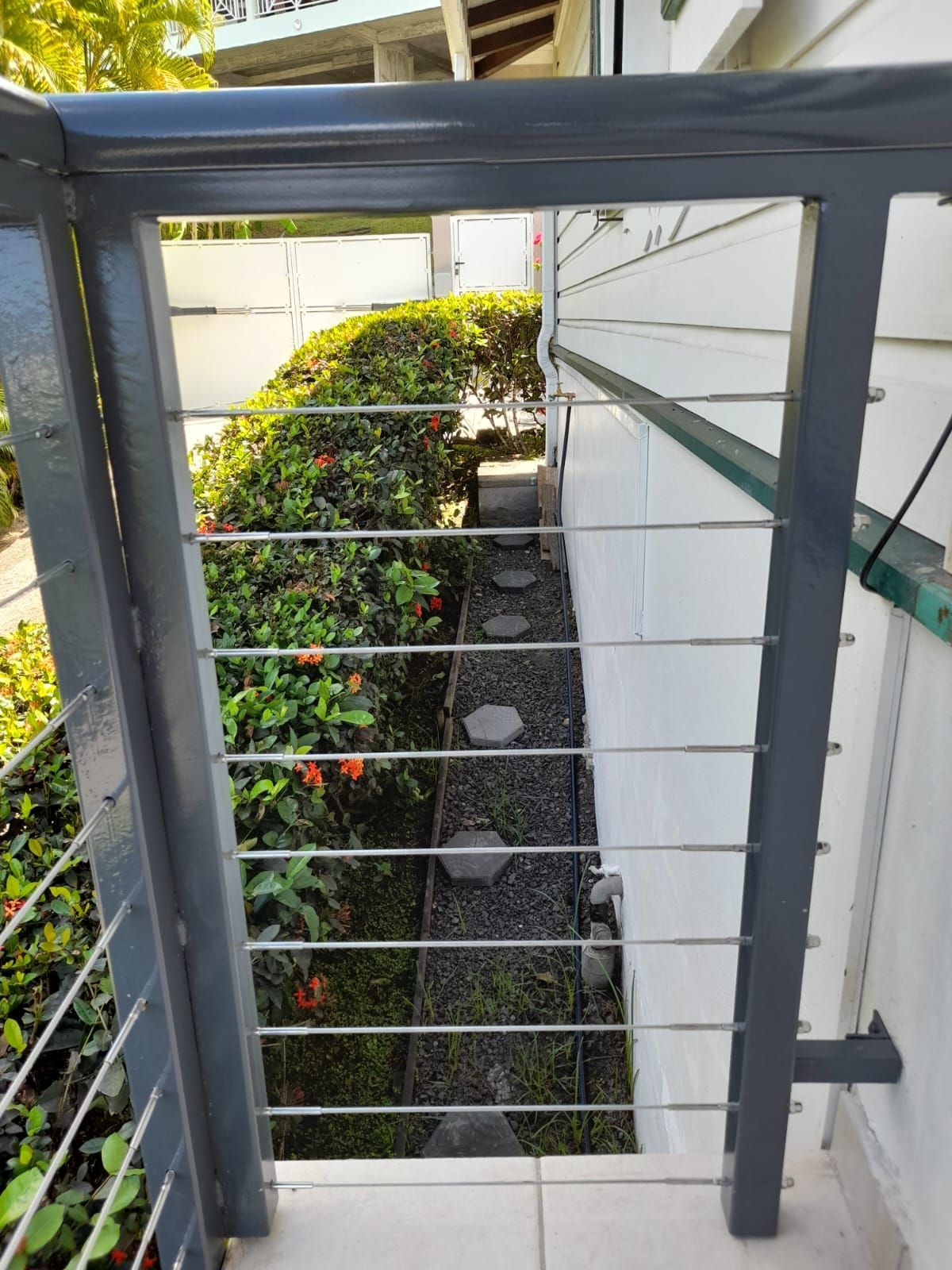 Un garde-corps en câble gris vu d'un balcon.