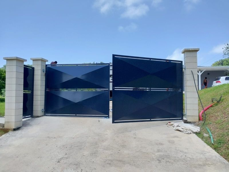 Un portail d'allée moderne en métal bleu foncé.