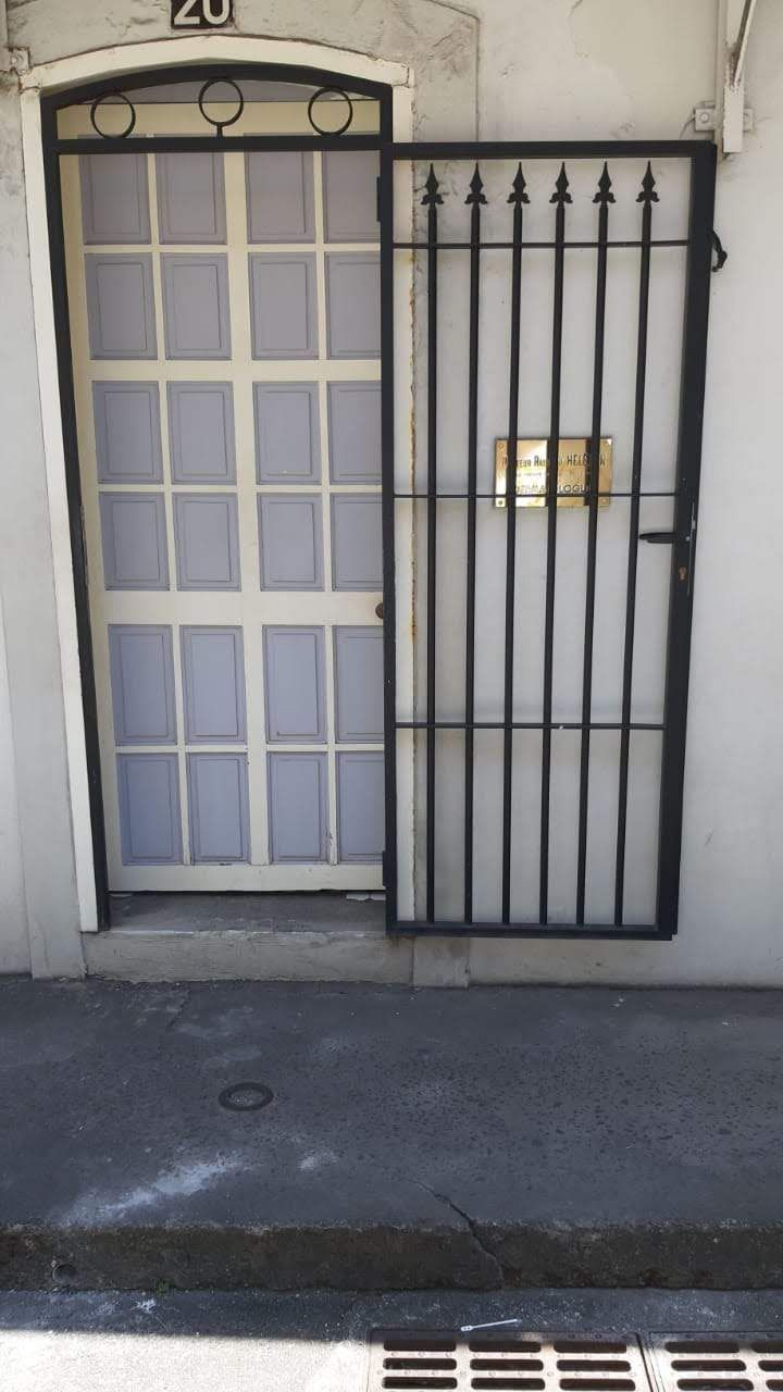 Une porte blanche équipée d'une grille de protection en métal noir.