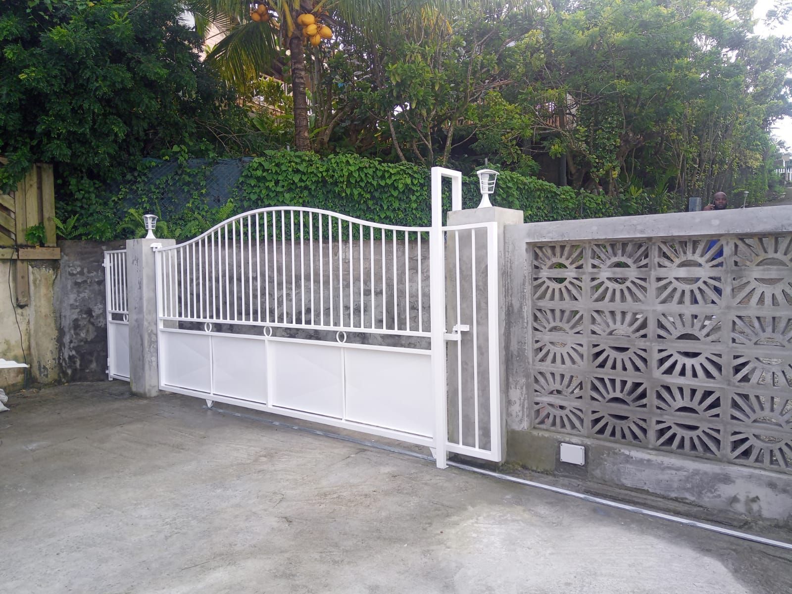 Un portail coulissant en métal blanc.