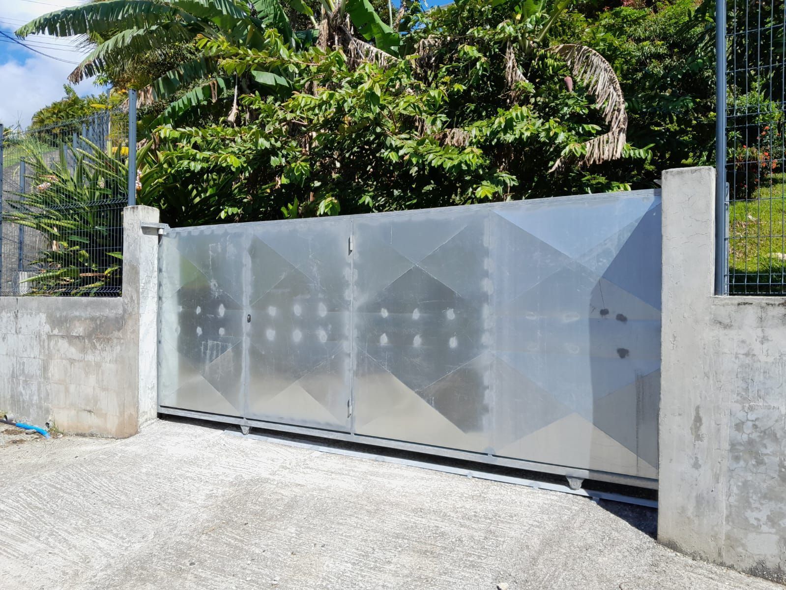 Un portail coulissant en métal à motif géométrique.