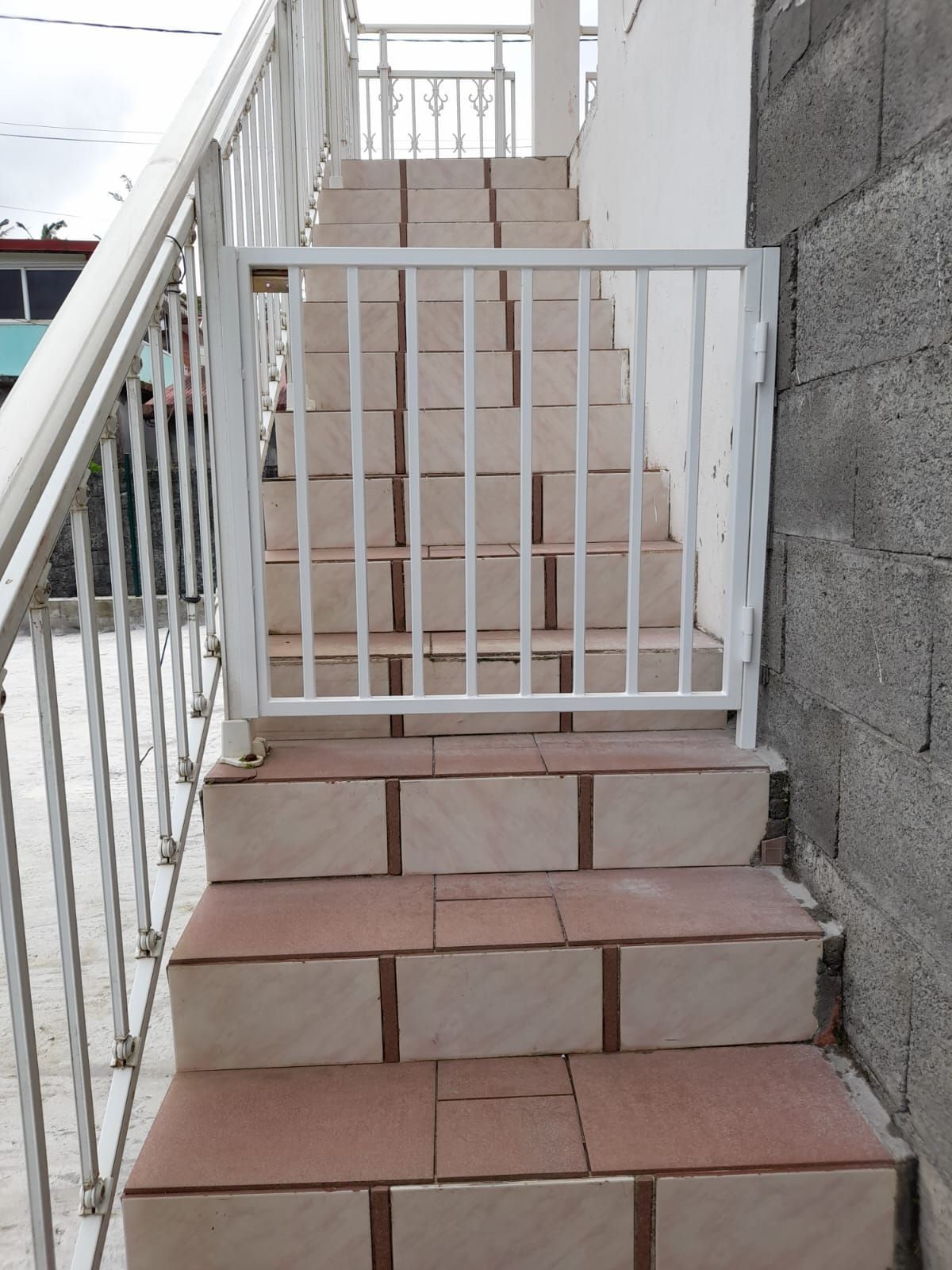 Barrière de sécurité en métal blanc installé sur un escalier extérieur.