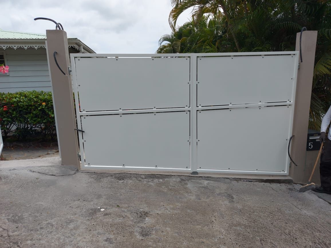 Une entrée avec un portail blanc.