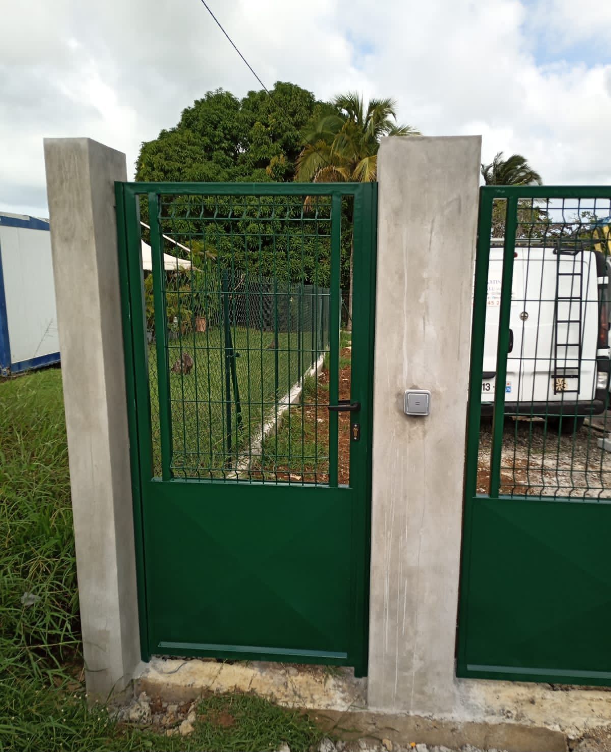 Un portillon piéton en métal vert.