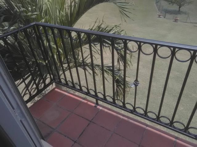 Un balcon avec une balustrade en fer forgé noir ornée de motifs circulaires.