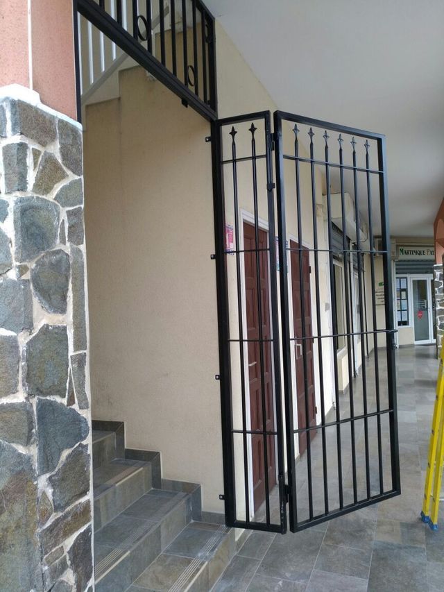 Une grille de protection en métal noir pour escaliers.