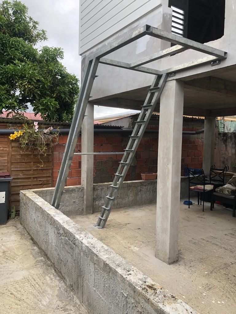 Un escalier métallique fixé à une structure en acier.