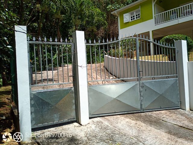 Un portail métallique orné de panneaux géométriques.