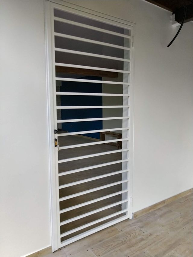 Une grille de sécurité en métal blanc à barreaux horizontaux.