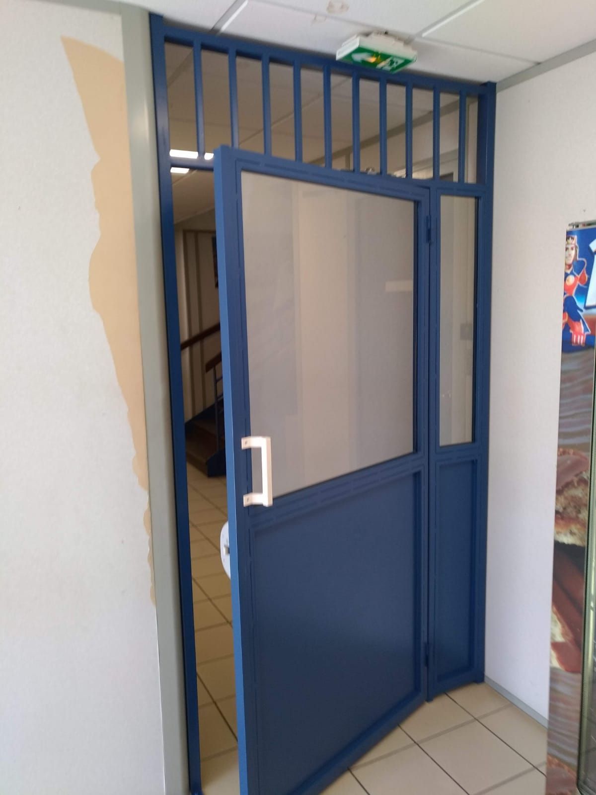 Une porte métallique bleue ouverte.