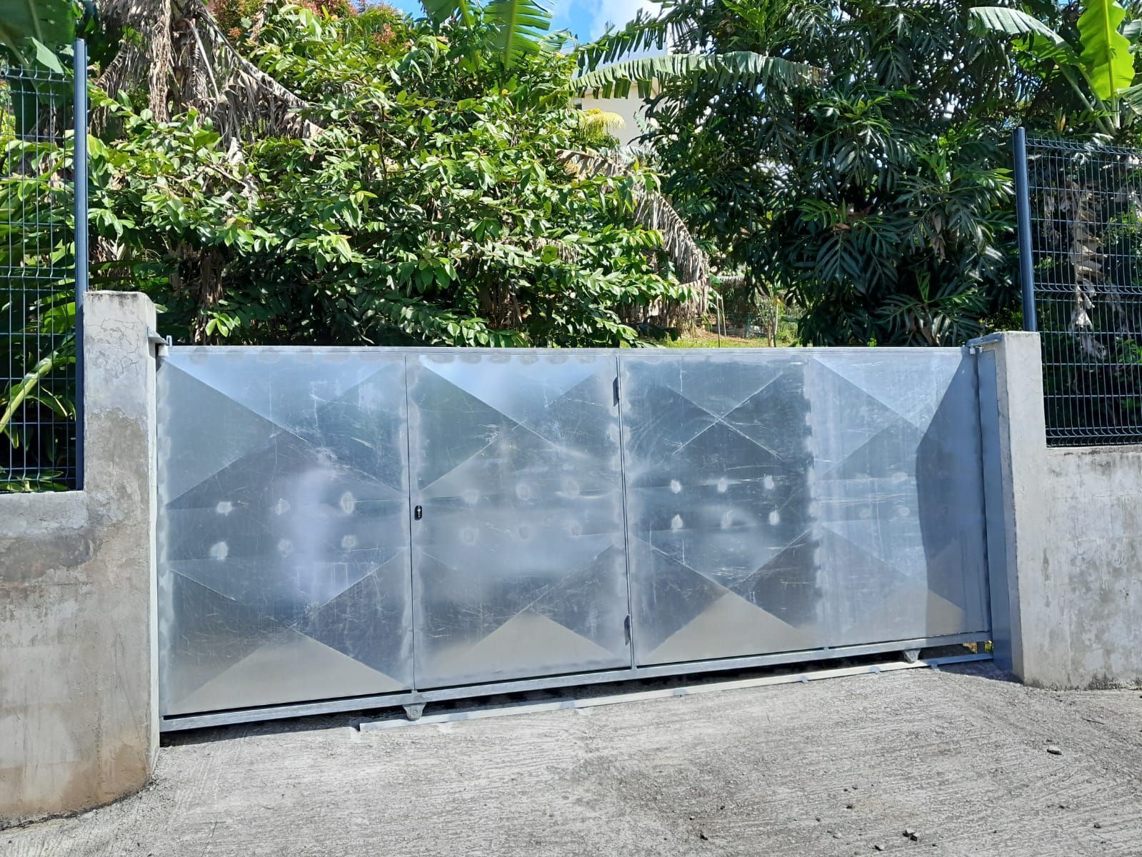 Un portail coulissant en métal à motif géométrique.