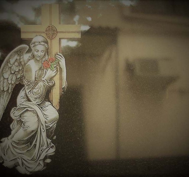 Una estatua de un ángel sosteniendo una cruz y una rosa.